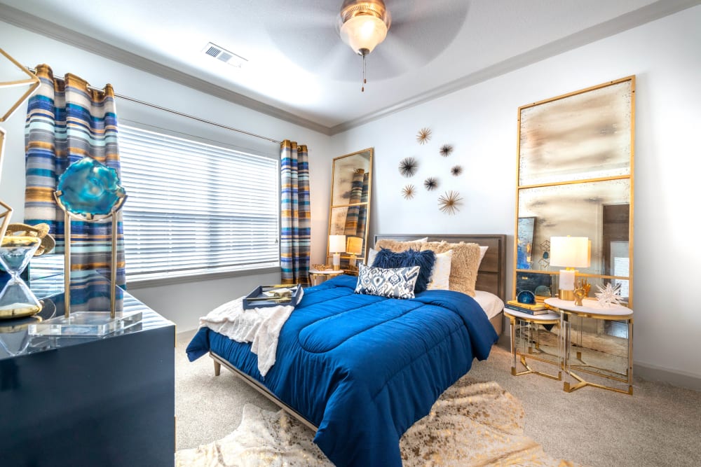 Model apartment's bedroom with a ceiling fan and plush carpeting at Olympus Carrington in Pooler, Georgia