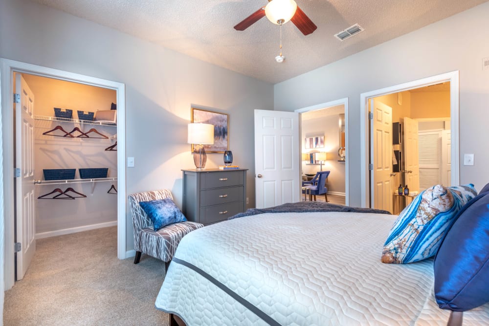 Walk-in closet and an en suite bathroom in a model home's primary bedroom at Olympus Fenwick in Savannah, Georgia