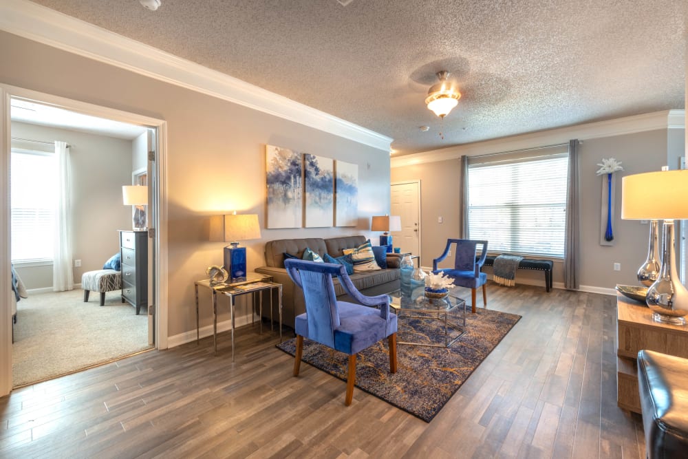 Hardwood flooring and modern furnishings in the living space of a model home at Olympus Fenwick in Savannah, Georgia