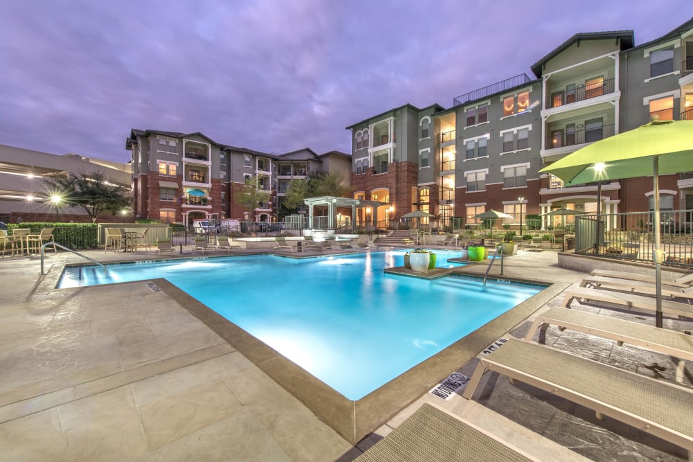 Underwater lights illuminating the pool at dusk at Olympus Las Colinas in Irving, Texas