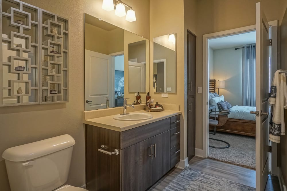 Quartz countertop and a large vanity mirror in a model home's primary bathroom at Olympus Northpoint in Albuquerque, New Mexico