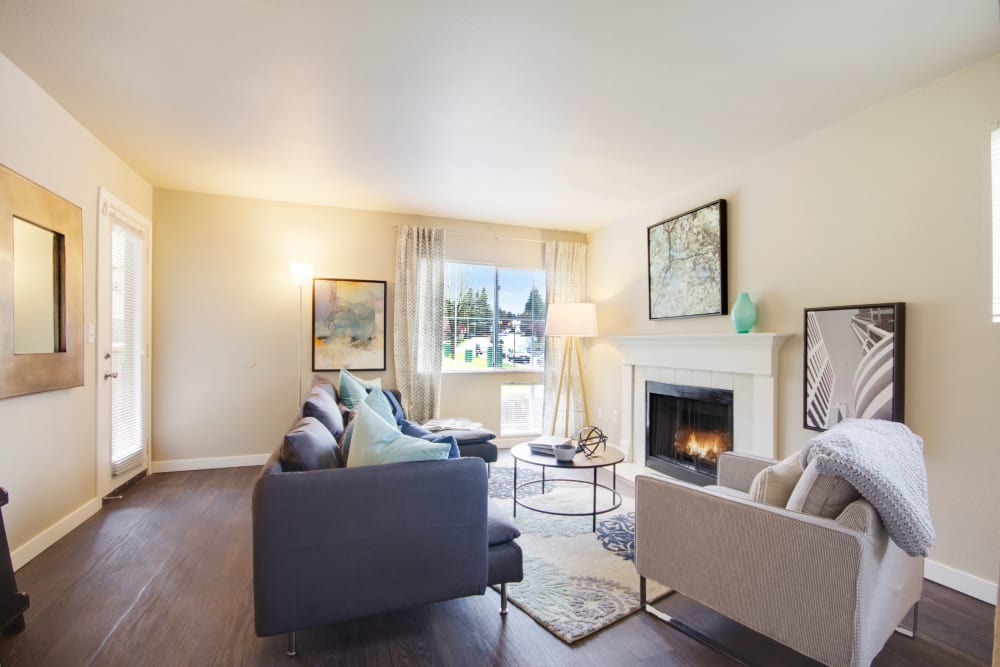 Contemporary living room with a wood-fueled fireplace at The Carriages at Fairwood Downs in Renton, Washington
