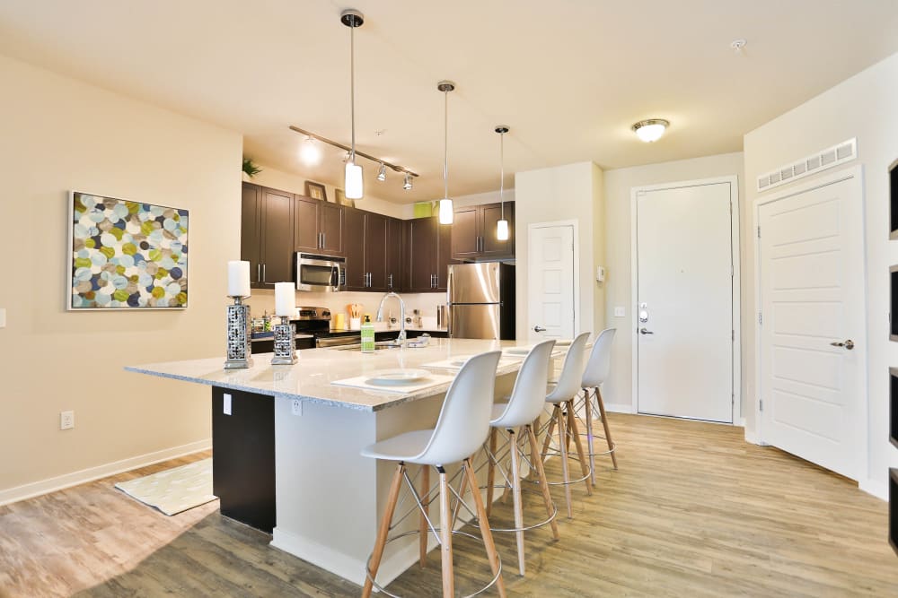 Custom lighting above the island and breakfast bar in a model home's kitchen at Olympus Steelyard in Chandler, Arizona