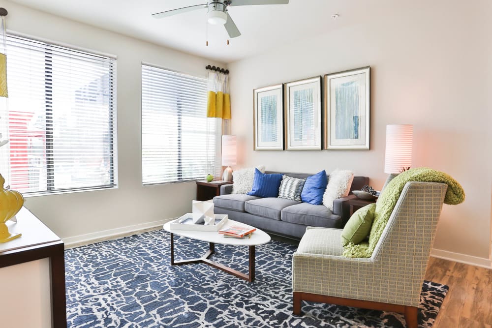 Ceiling fan and bay windows in the living space of a model apartment at Olympus Steelyard in Chandler, Arizona