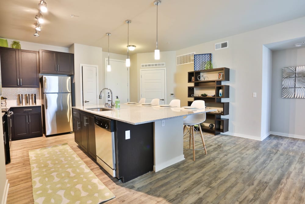 Island with a granite countertop in a model home's kitchen at Olympus Steelyard in Chandler, Arizona