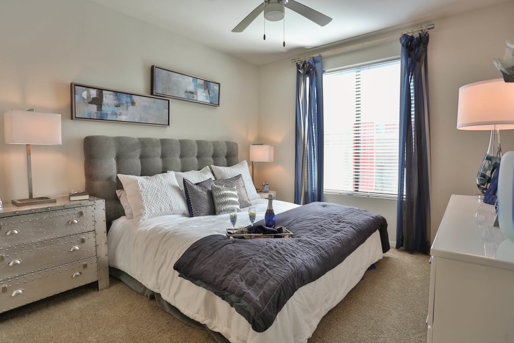 Model home's master bedroom with plush carpeting and comfortable furnishings at Olympus Steelyard in Chandler, Arizona