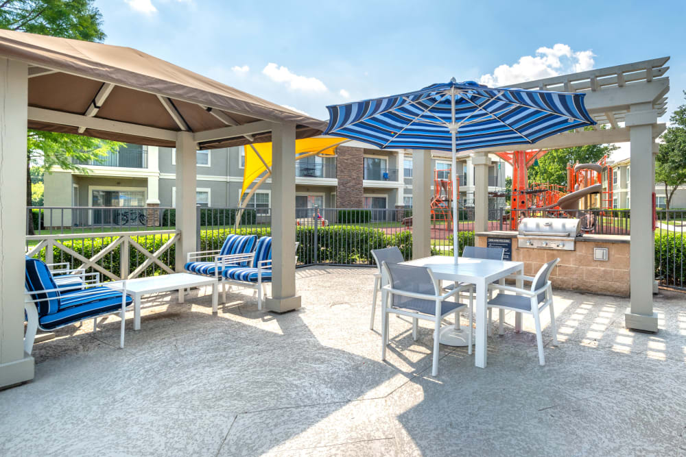 Shaded lounge seating at the barbecue area with gas grills at Olympus Stone Glen in Keller, Texas