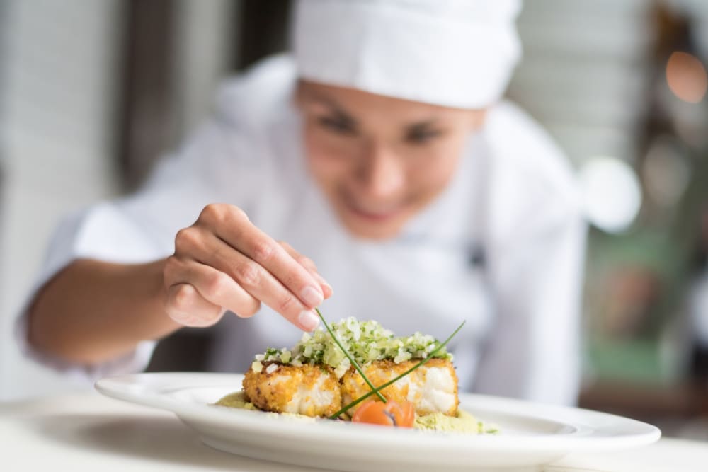 Expert chef topping off a meal at Keystone Place at Richland Creek in O'Fallon, Illinois