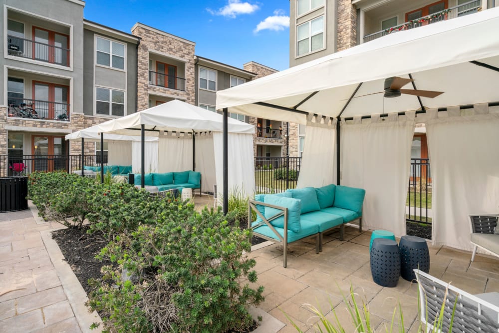 Private cabanas with fans by pool at Olympus Grand Crossing in Katy, Texas