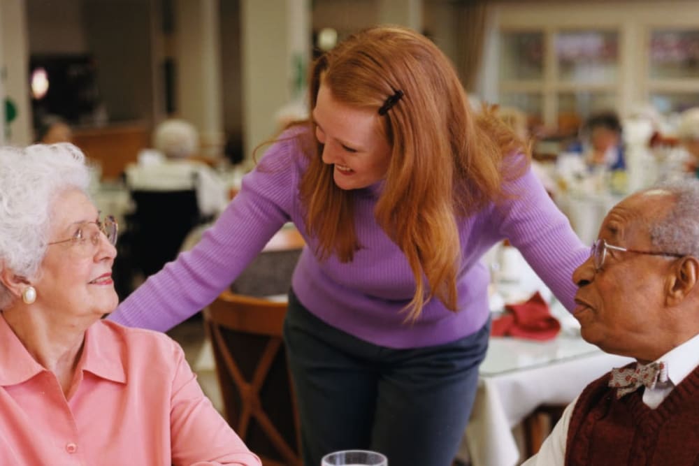 Residents talk with staff in restaurant-style dining room  at Milestone Senior Living Faribault in Faribault, Minnesota. 