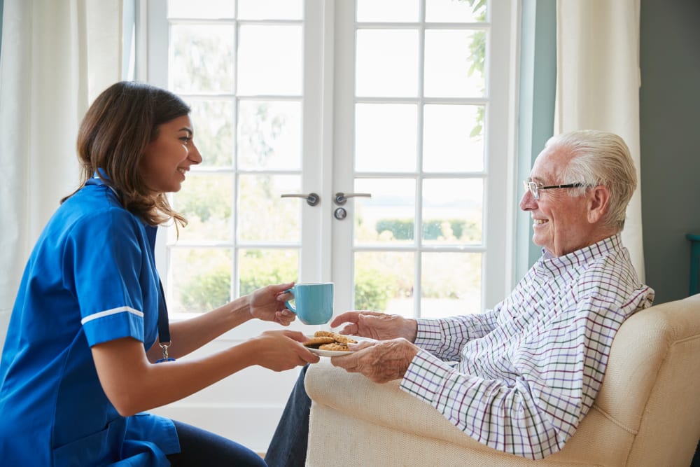 Staff member visiting resident in assisted living apartment at Milestone Senior Living Woodruff in Woodruff, Wisconsin.