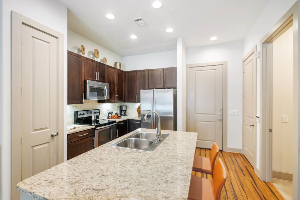 Beautiful granite countertops in a model home's kitchen at Olympus Sierra Pines in The Woodlands, Texas