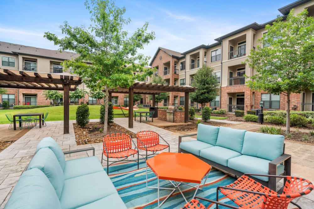 Mature trees and well-manicured landscaping in the courtyard lounge at Olympus Sierra Pines in The Woodlands, Texas