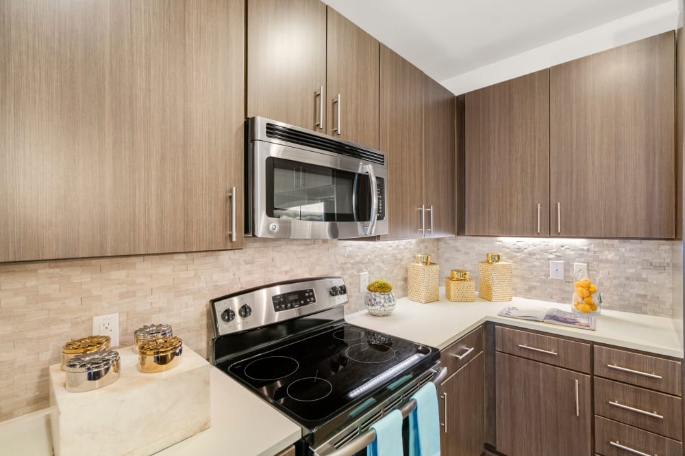 Custom wood cabinetry and stainless-steel appliances in a model home's gourmet kitchen at Olympus Grand Crossing in Katy, Texas