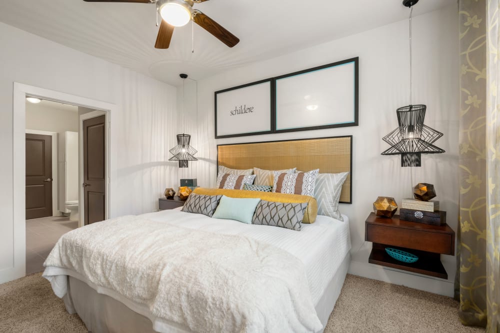 Ceiling fan and plush carpeting in a model home's bedroom at Olympus Grand Crossing in Katy, Texas