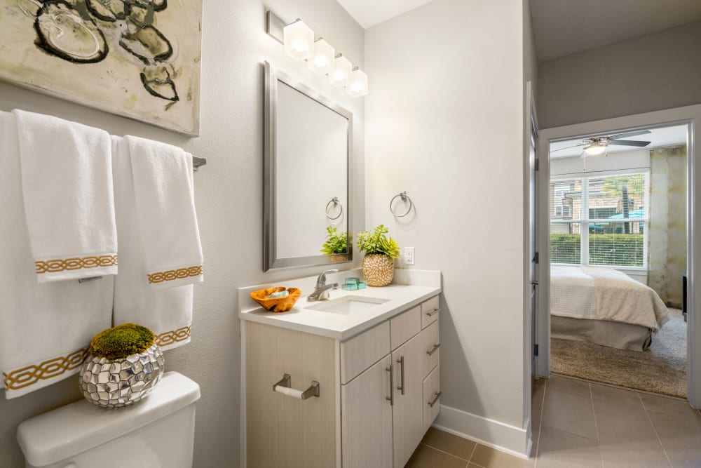 Well-lit en suite bathroom in a model home at Olympus Grand Crossing in Katy, Texas