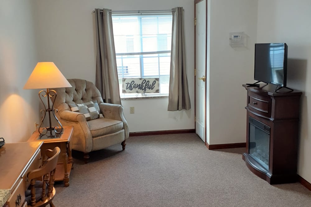 Cozy living room with large window at Clover Ridge Place in Maquoketa, Iowa. 