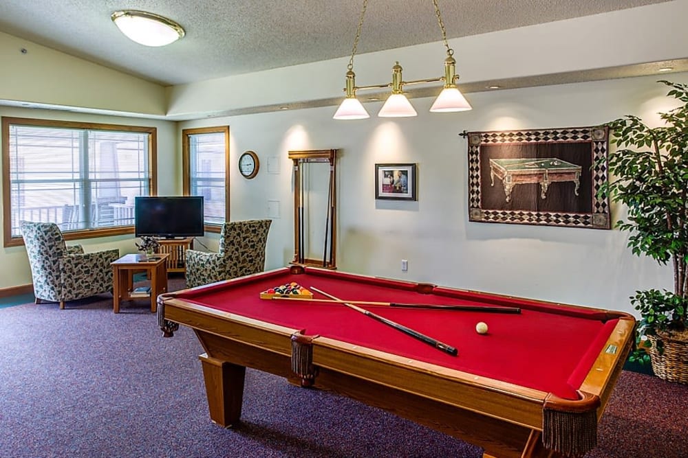 Resident game room with pool table and TV at Prairie Hills Clinton in Clinton, Iowa.