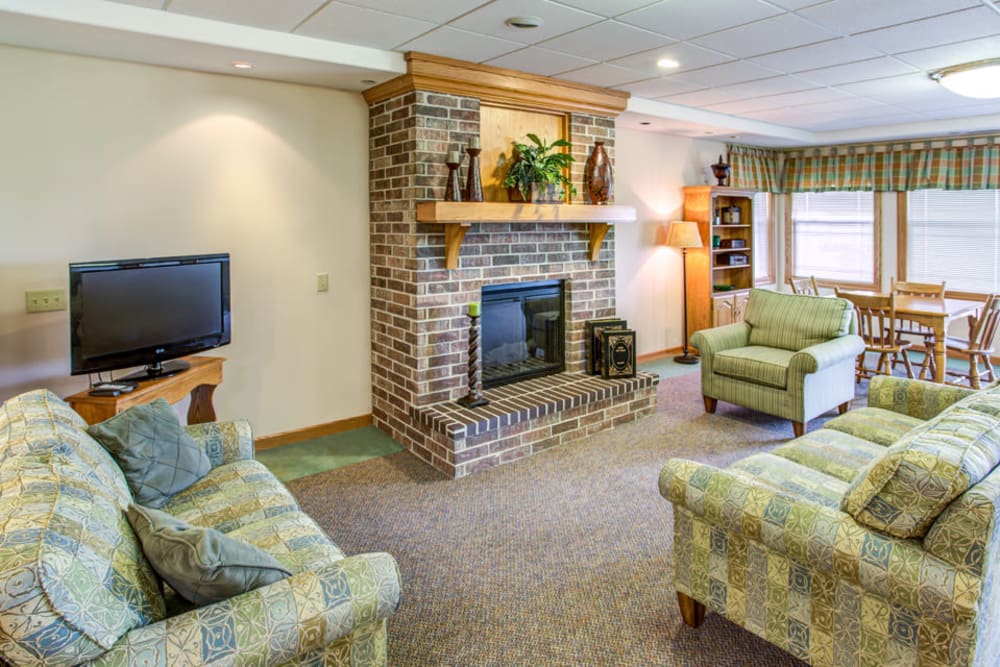 Comfortable lounge with fireplace and TV at Addington Place of Carroll in Carroll, Iowa.