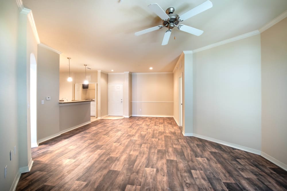 Hardwood flooring and a ceiling fan in the open-concept living area of a model home at Mirador & Stovall at River City in Jacksonville, Florida