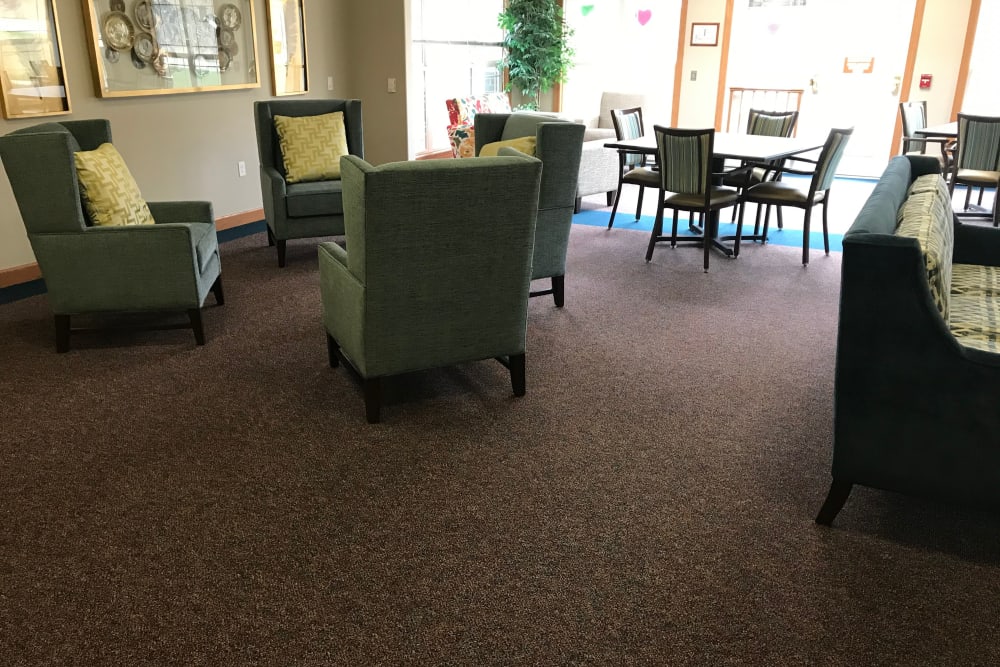 Bright resident lounge with comfortable seating and large windows at Addington Place of Des Moines in Des Moines, Iowa.