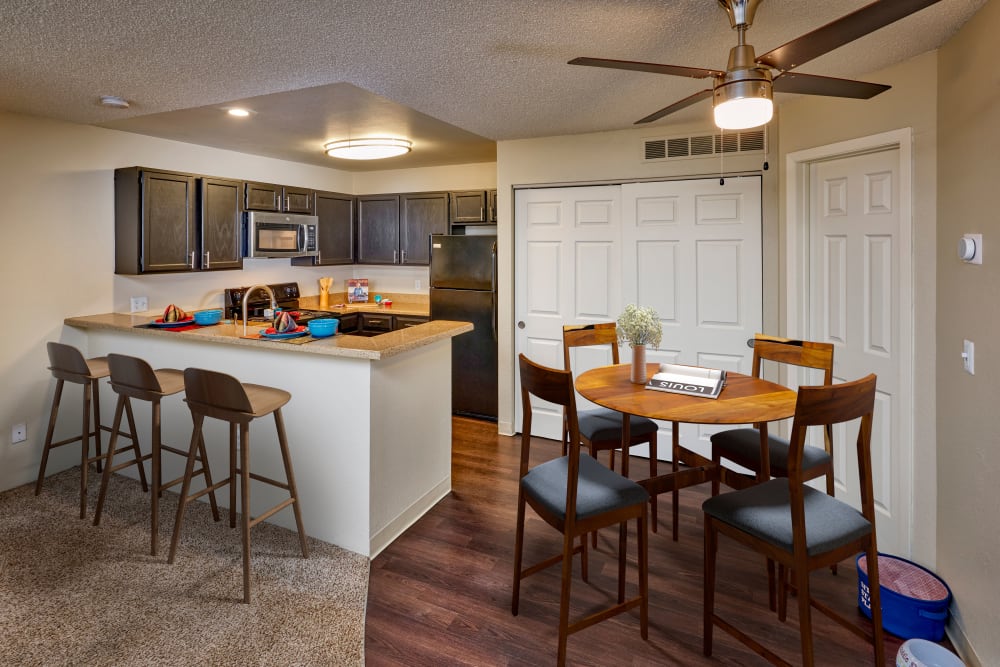 Kitchen with brown cabinets and a stacked washer and dryer at Bluesky Landing Apartments in Lakewood, Colorado