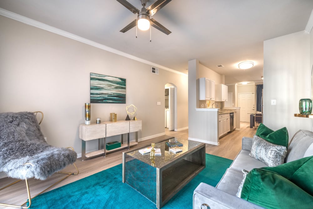 Modern furnishings and a ceiling fan in the living area of a model apartment at Olympus Town Center in Keller, Texas