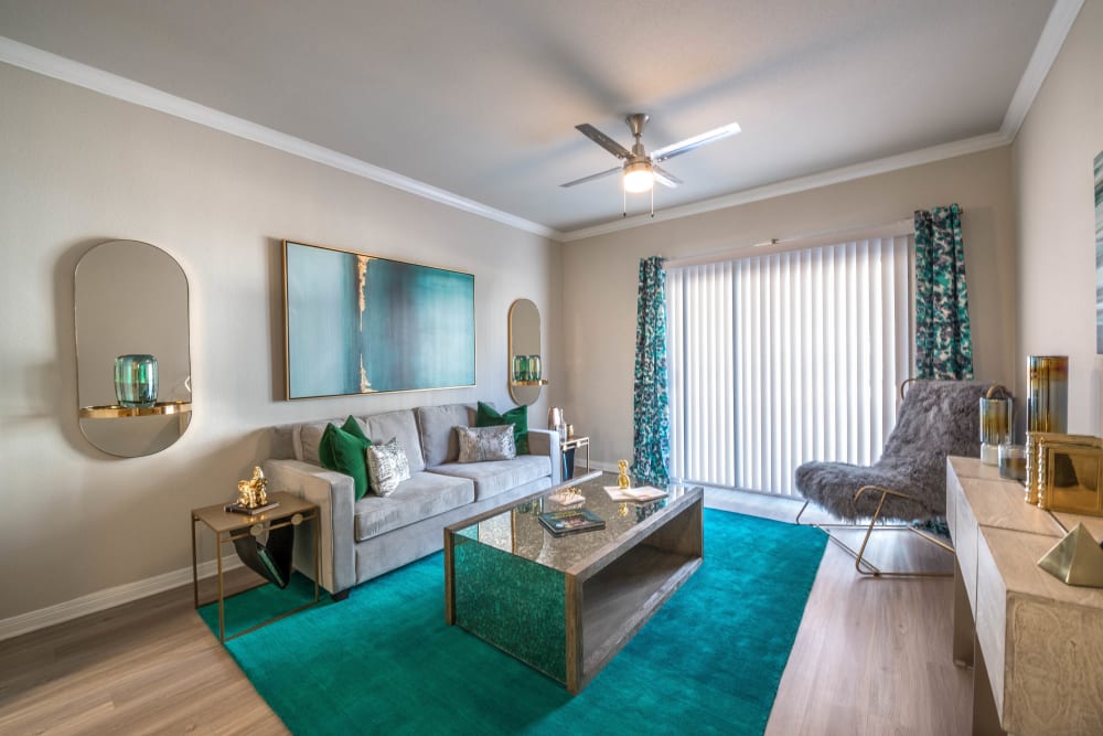 Well-furnished living area with a ceiling fan in a model home at Olympus Town Center in Keller, Texas