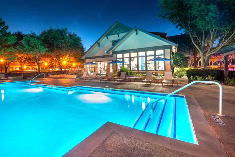 Swimming pool at twilight with the underwater lights on at Olympus Town Center in Keller, Texas