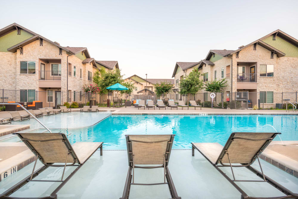 Lounge chairs in the swimming pool's sun deck at Olympus Waterford in Keller, Texas