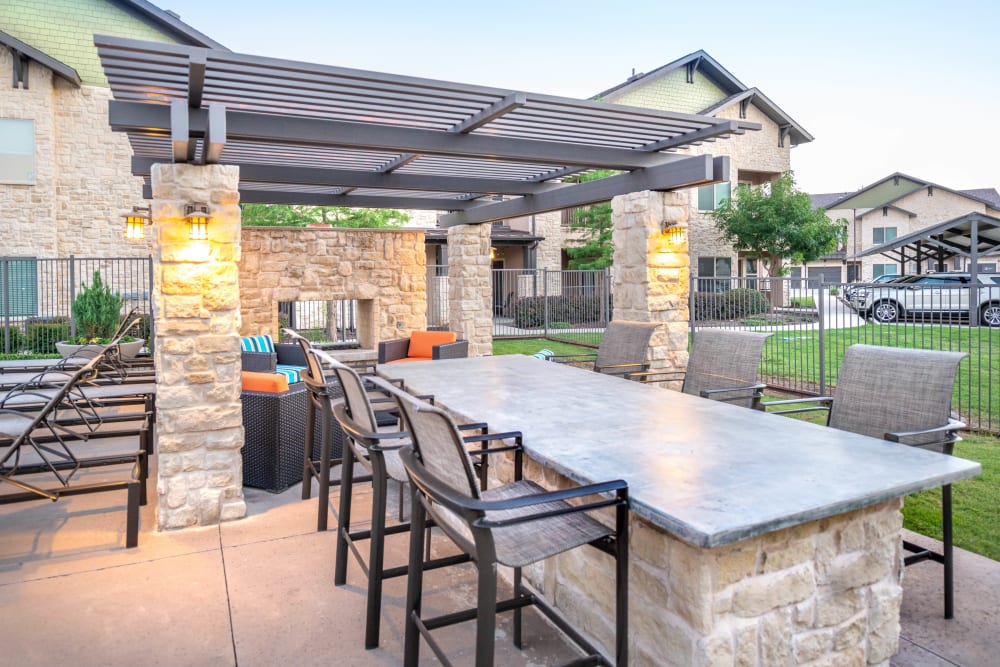 Barbecue area with bar seating at Olympus Waterford in Keller, Texas