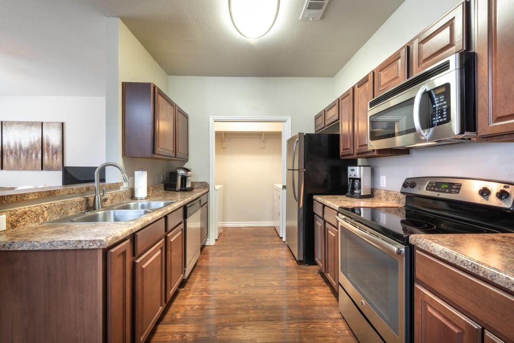 Gourmet kitchen with stainless-steel appliances in a model home at Olympus Willow Park in Willow Park, Texas