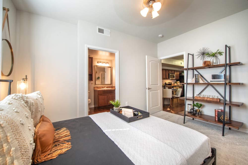 Well-furnished primary bedroom with a ceiling fan and plush carpeting at Olympus Willow Park in Willow Park, Texas