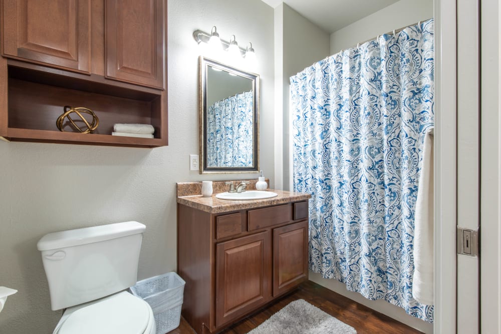 Cherry wood cabinetry in a model home's bathroom at Olympus Willow Park in Willow Park, Texas