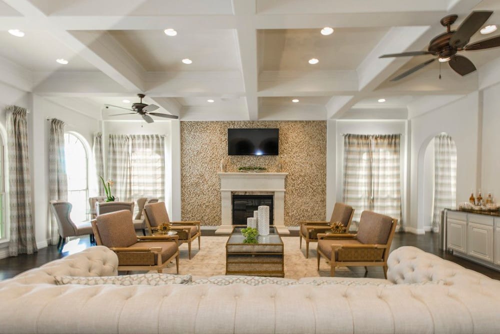 Luxurious resident clubhouse lounge in front of the fireplace at Olympus Woodbridge in Sachse, Texas