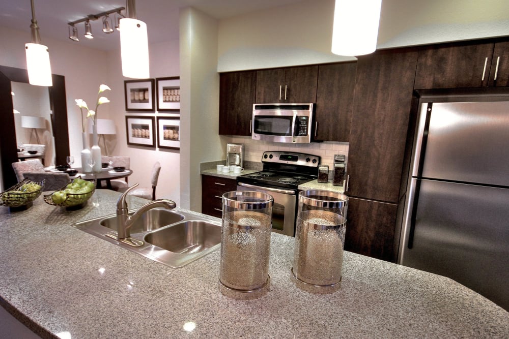 Gourmet kitchen with an island and granite countertops in a model home at Redstone at SanTan Village in Gilbert, Arizona