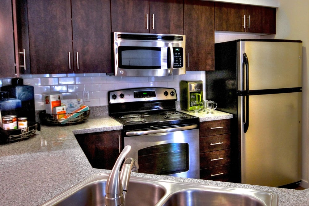 Rich, dark wood cabinetry in a model home's kitchen at Redstone at SanTan Village in Gilbert, Arizona
