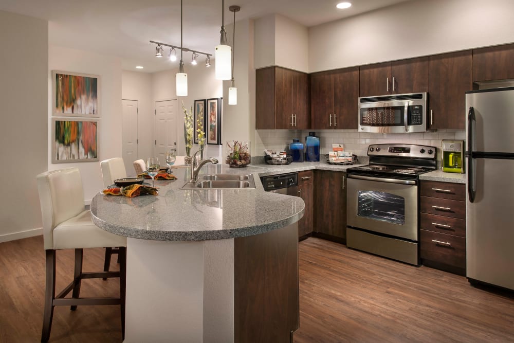 Beautiful dark wood cabinetry and hardwood flooring in a model home's kitchen at Redstone at SanTan Village in Gilbert, Arizona