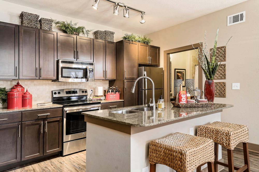 Gourmet kitchen with granite countertops and an island in a model home at Sedona Ranch in Odessa, Texas