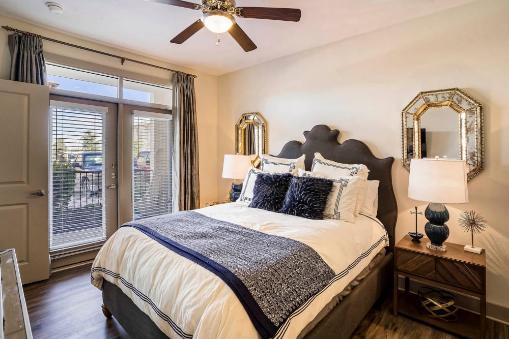 Modern furnishings and a ceiling fan in a model home's bedroom at Sundance Creek in Midland, Texas