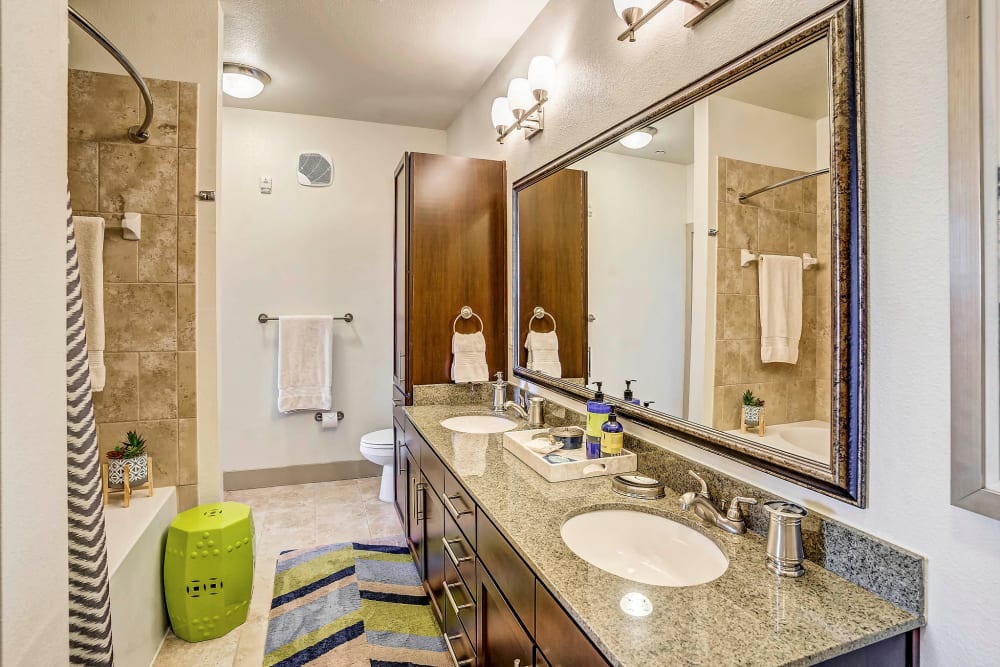 Oversized vanity mirror and a granite countertop in a model home's bathroom at Sundance Creek in Midland, Texas