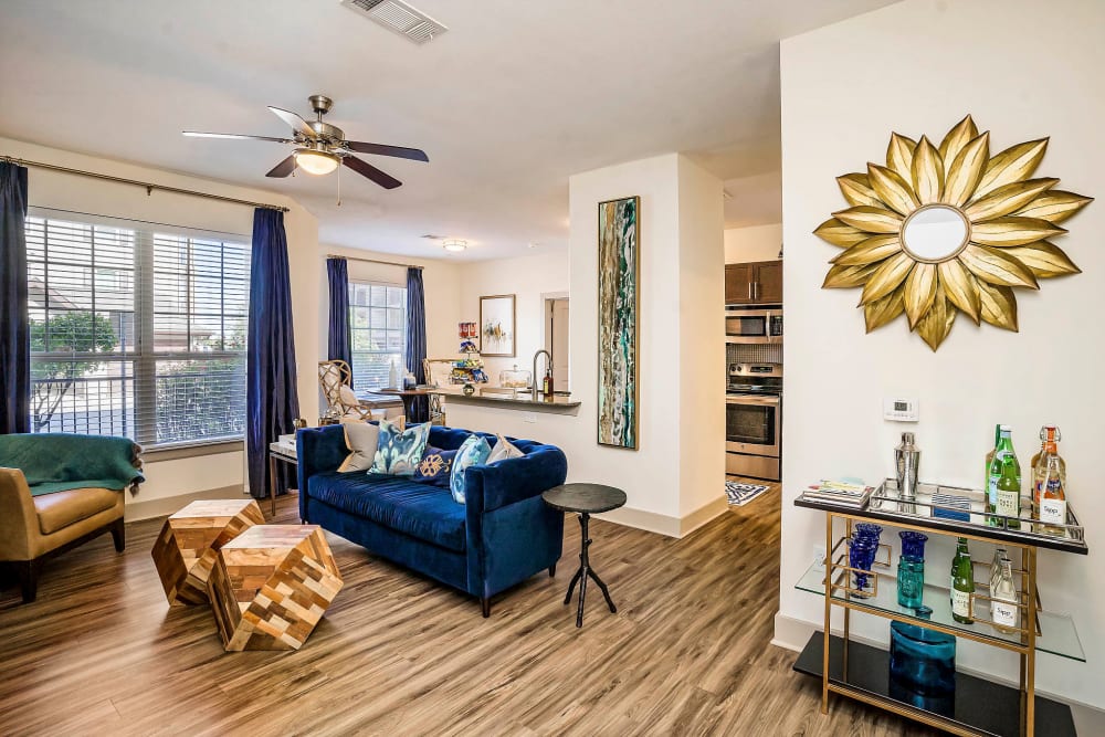 Hardwood floors and a ceiling fan in a model apartment's living area at Sundance Creek in Midland, Texas