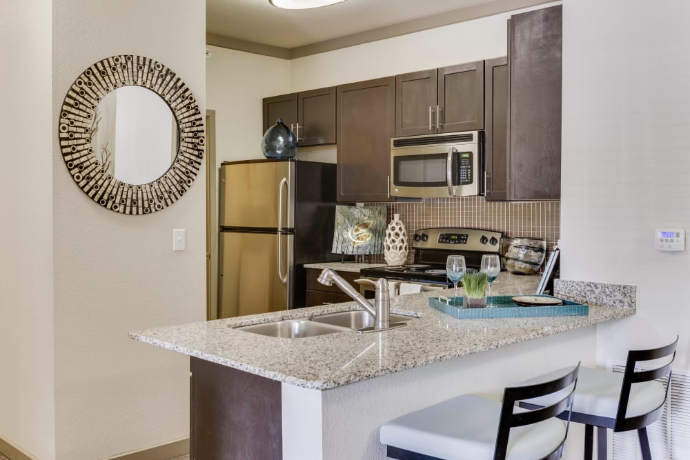 Stainless-steel appliances and a breakfast bar in a model home's kitchen at Tacara at Westover Hills in San Antonio, Texas