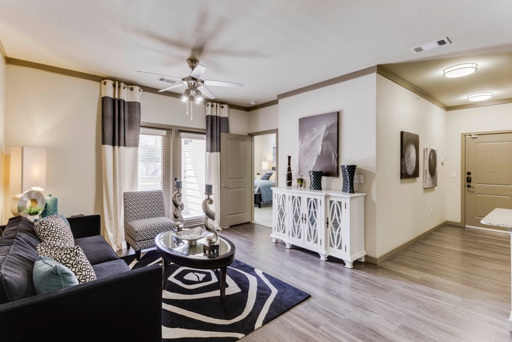 Well-furnished living area with a ceiling fan in a model home at Tacara at Westover Hills in San Antonio, Texas