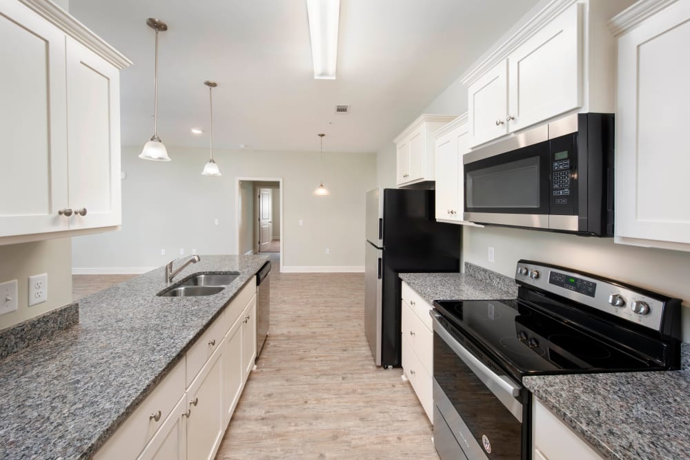 Spacious kitchen with bright white cabinetry in a model home at The Enclave in Brunswick, Georgia