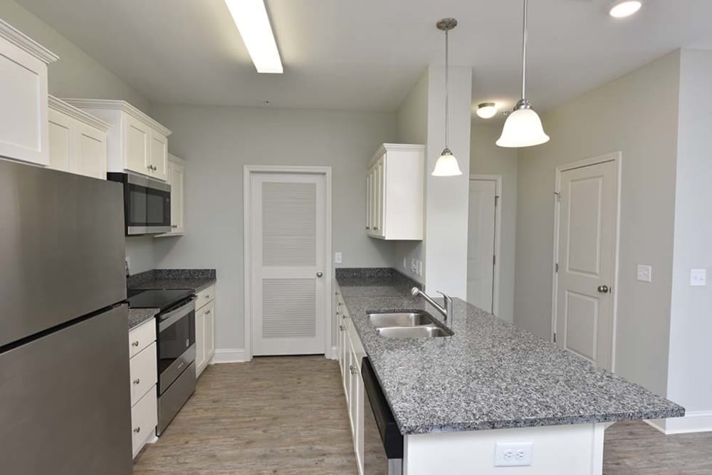 Pantry and stainless-steel appliances in a model apartment's kitchen at The Enclave in Brunswick, Georgia