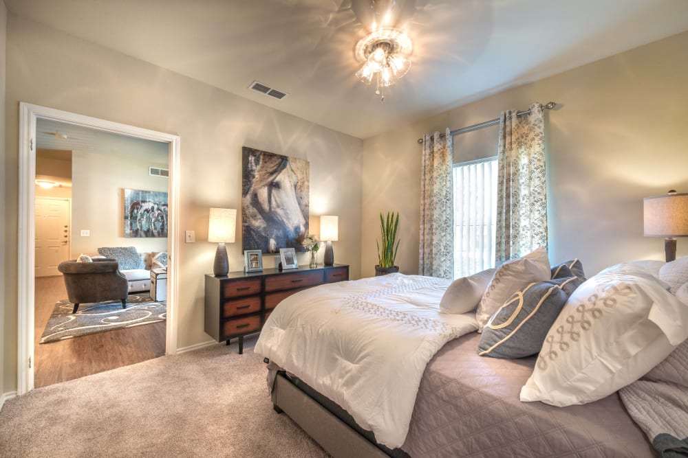 Large and well-furnished master bedroom with plush carpeting in a model home at The Ranch at Shadow Lake in Houston, Texas