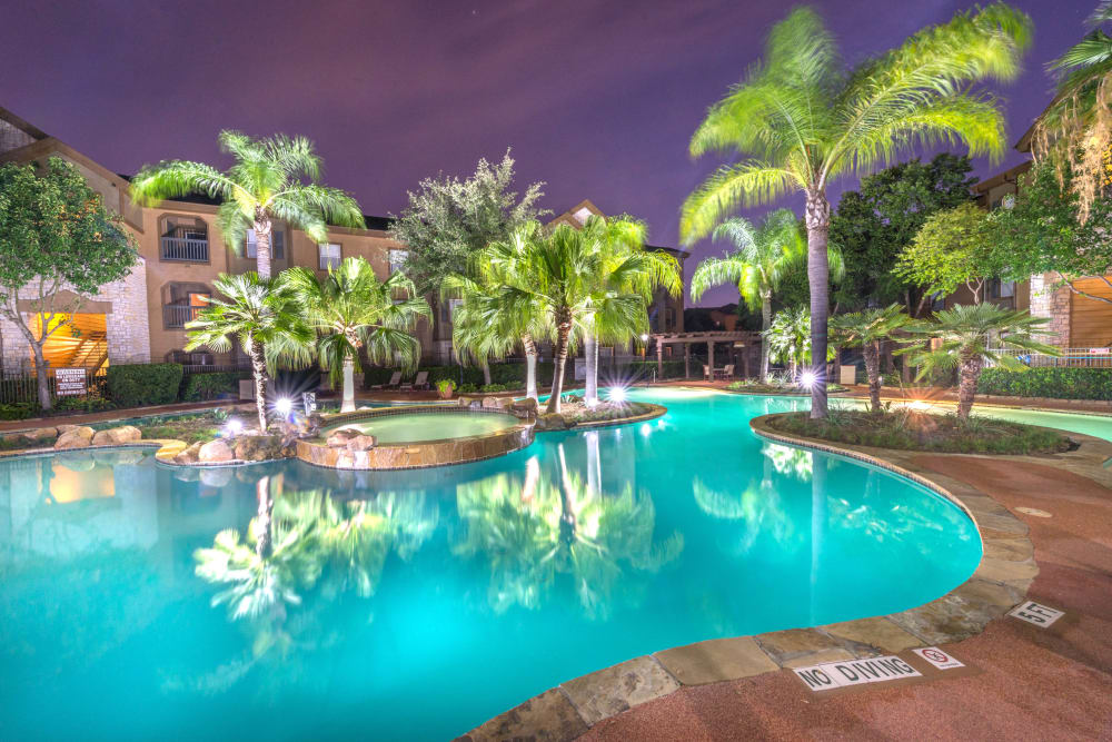Resort-style swimming pool area brightly illuminated at dusk at The Ranch at Shadow Lake in Houston, Texas