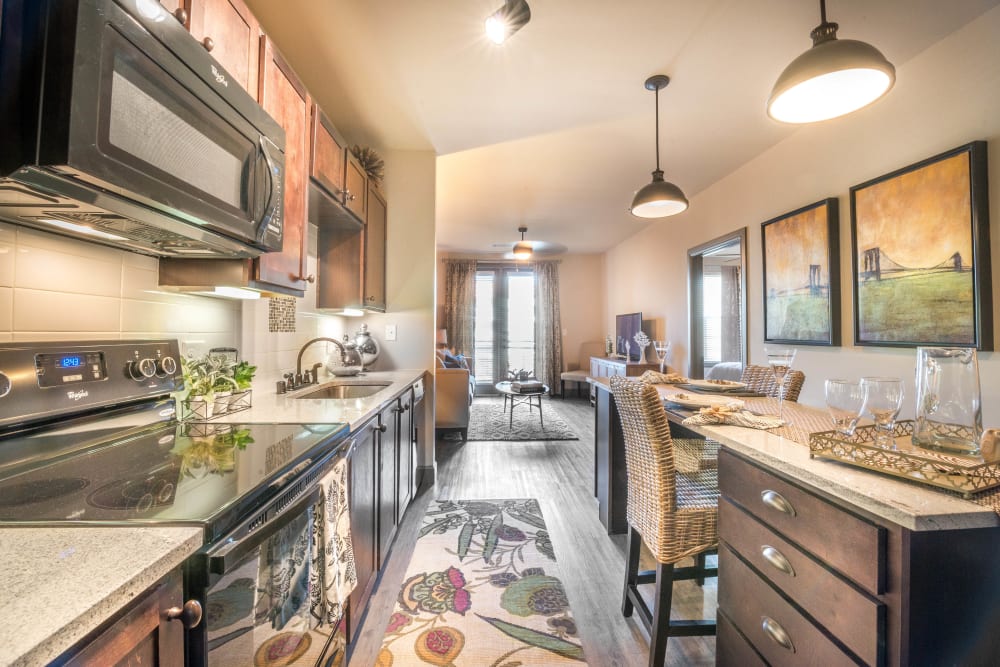 Spacious open-concept gourmet kitchen with granite countertops in a model apartment at Union At Carrollton Square in Carrollton, Texas