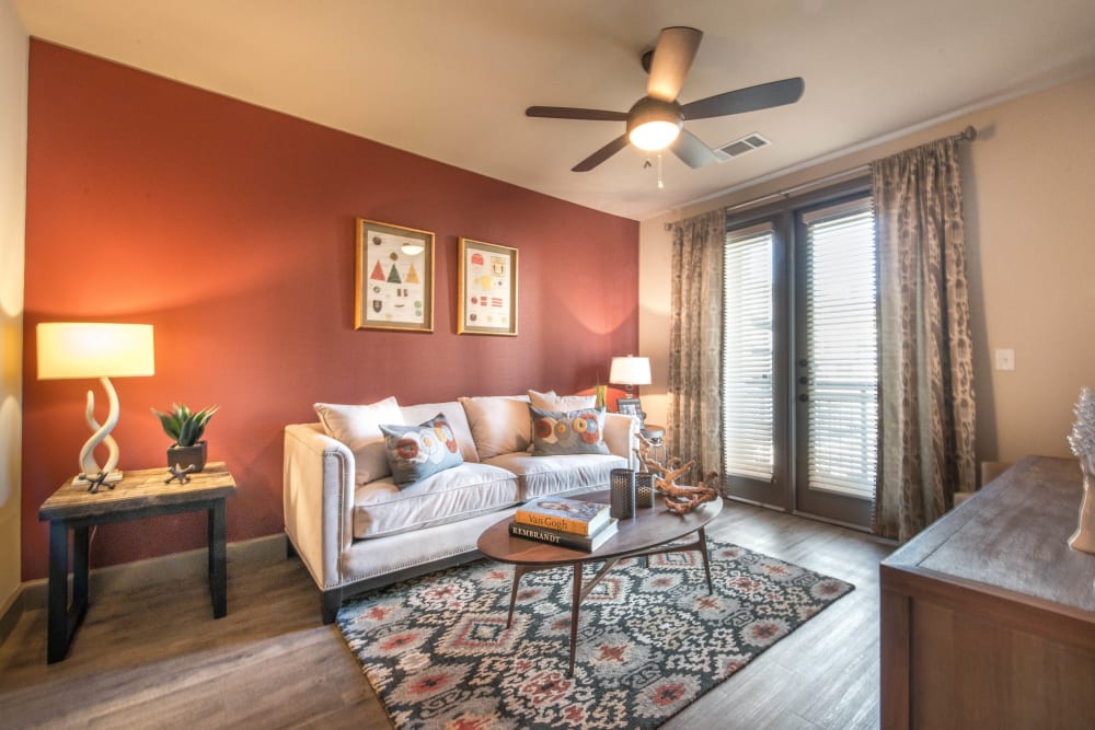 Accent wall and a ceiling fan in the living area of a model apartment at Union At Carrollton Square in Carrollton, Texas